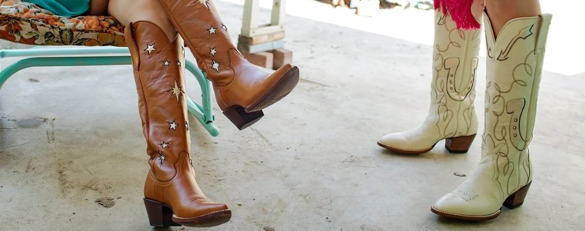 Two pairs of western cowboy boots shown on legs in a real setting: one pair is tan leather with star details, and the other is off-white with buck stitch and horse shoe design. 